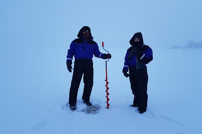 Ice fishing by car with hot beverages at Pyhä-Luosto - Making the first hole through the ice