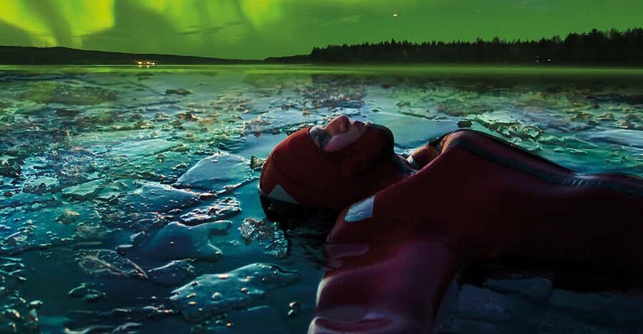Levi: Ice Floating and Northern Lights Tour - Lying in an Arctic lake beneath the night sky